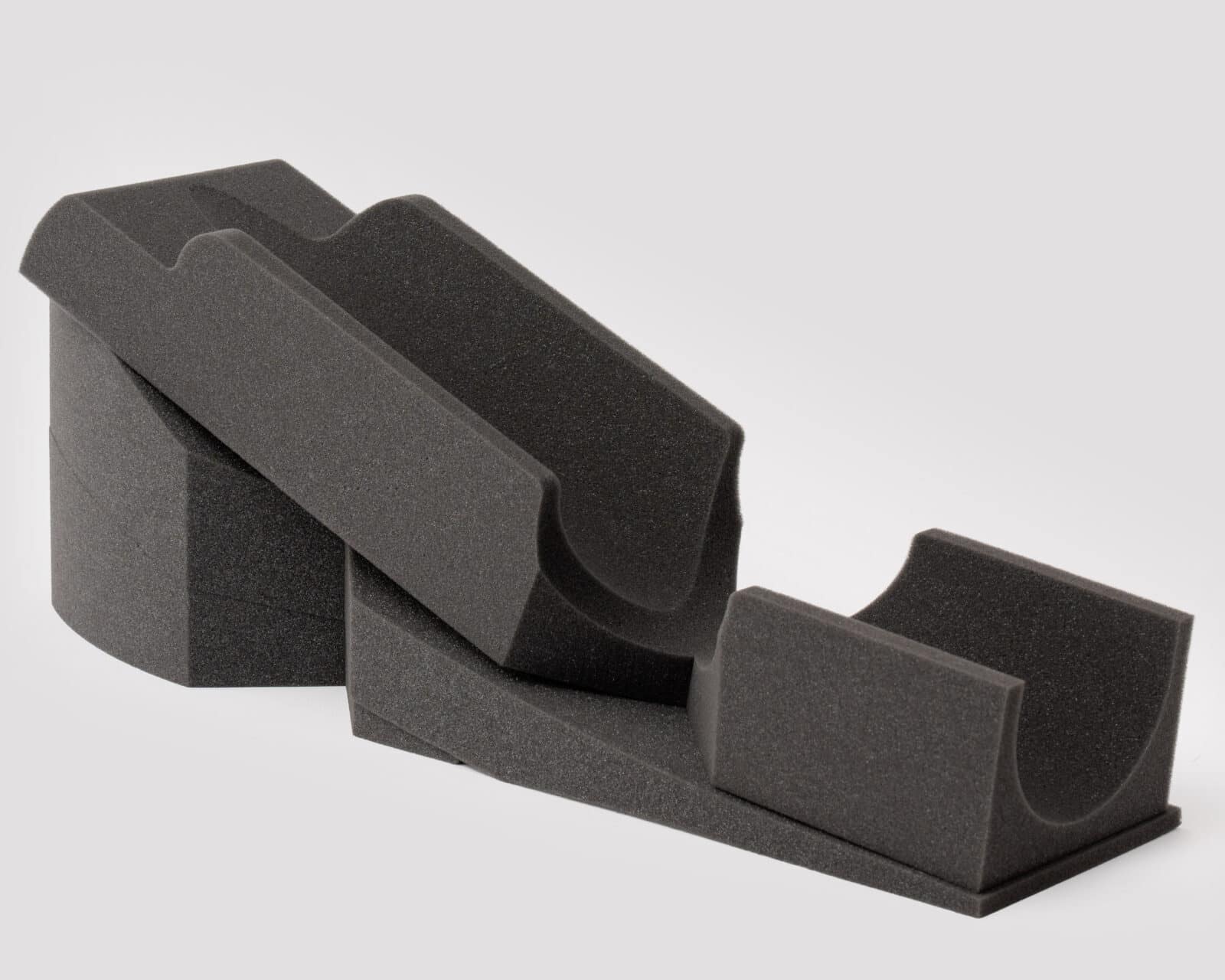 A multi-part surgical positioner in dark gray foam with hotspots for more information.